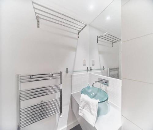a white bathroom with a sink and a mirror at Glasgow, Finnieston Luxury 2 Bed with parking, e-check in, hi-fi in Glasgow