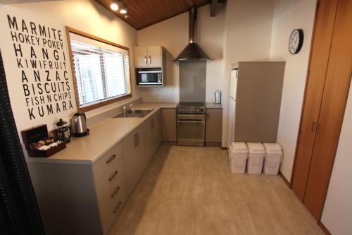a large kitchen with a sink and a refrigerator at Aspen on King in Timaru