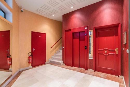 un pasillo con puertas rojas y una escalera en Wilson New Home, en Saint-Denis