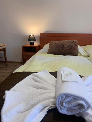 a bed with white towels on it with a lamp at Aranykorona Hotel in Miskolc