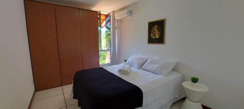 um pequeno quarto com uma cama e uma janela em COPDS0103 - Condomínio Aldeiotta em Salvador