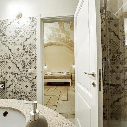 a bathroom with a sink and a room with a bed at Mikasa in Matera