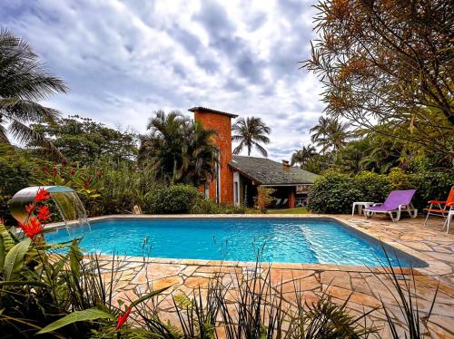 uma piscina em frente a uma casa em Casa a 180m da Praia do Toque Toque Pequeno SP em São Sebastião