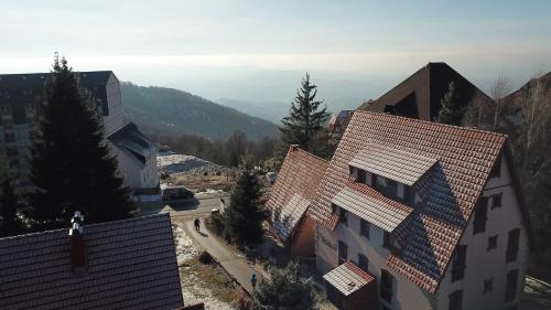 arial view of a building with a mountain in the background at Vila Milica Apartmani in Kopaonik