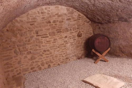 Cette chambre est dotée d'un mur en briques, d'un bol en bois et d'une croix. dans l'établissement Cal Vallverdú 2I, à Preixana