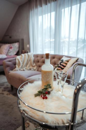 a table with a bottle of wine and glasses on it at Apartmany pod Pustevnami in Prostřední Bečva