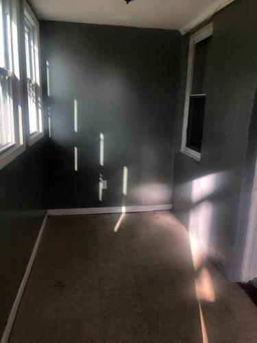 an empty room with windows and a dark wall at Cheerful Studio short walk to UHS near Lourdes & BU in Johnson City
