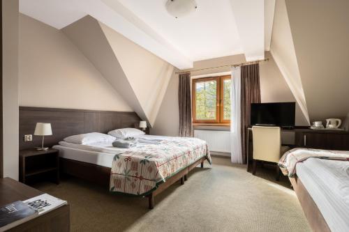 a hotel room with two beds and a window at Dom Wczasowy Grań in Zakopane