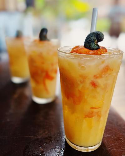 a row of three cocktails sitting on a table at Pousada Minha Praia in João Pessoa