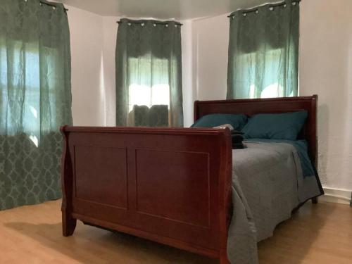 a bedroom with a bed and two windows with green curtains at Spacious 3 bed by Wilson, Lourdes Hospitals near Vestal in Johnson City