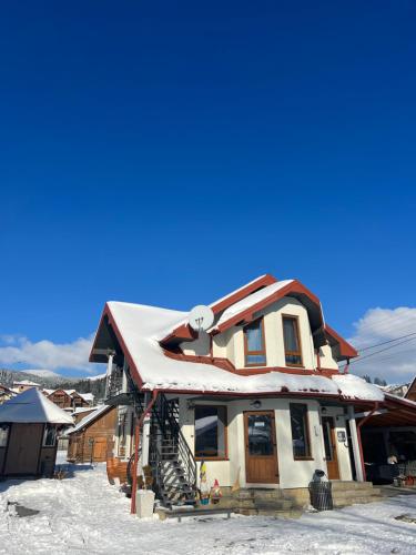 a house with snow on the roof at Zatyshok nad Prutom in Bukovel