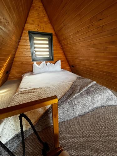 a bedroom with a bed in a wooden cabin at Rock Valley Cabins A-frame in Ibăneşti