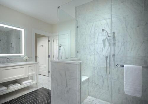 a white bathroom with a shower and a sink at The Equestrian in Ocala