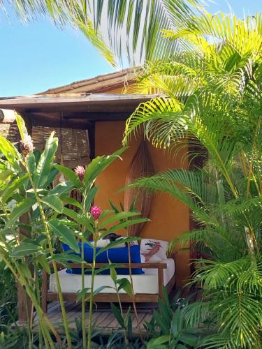 a resort room with a bed and some plants at Casa Paula in Barra Grande