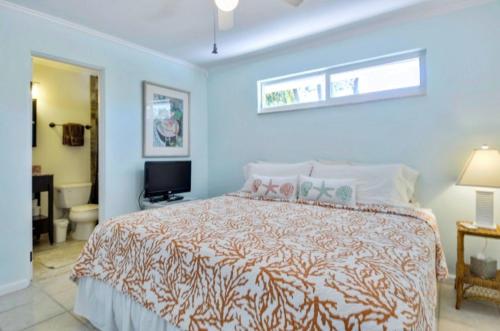 um quarto com uma cama grande e uma televisão em Sunshine Place em Islamorada