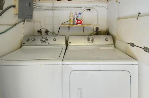 two white washing machines in a small kitchen at Sunshine Place in Islamorada
