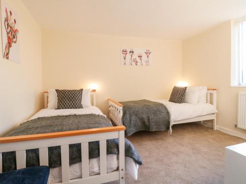 a bedroom with two beds and two windows at 8 Church Lane in Checkley