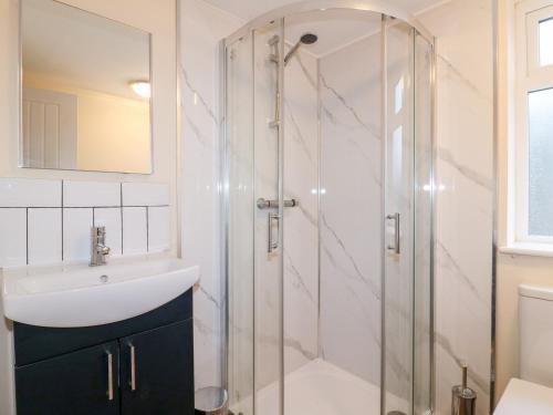 a bathroom with a glass shower and a sink at 8 Church Lane 
