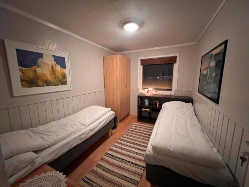 a small bedroom with two beds and a window at Large house with spectacular view in Tromsø