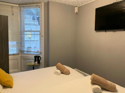 1 dormitorio con 1 cama con 2 zapatillas en Relax Inn Guest House, en Brighton & Hove