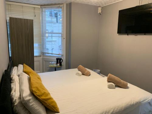 um quarto com uma grande cama branca com almofadas amarelas em Relax Inn Guest House em Brighton & Hove