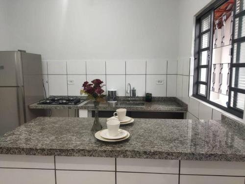 a kitchen with two cups and plates on a counter at Kitnet 3 - próximo ao centro de Jacareí in Jacareí