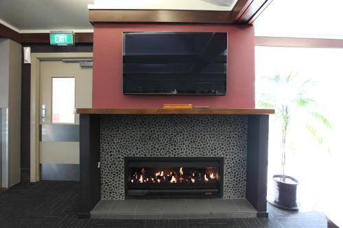 a fireplace with a television on top of it at Hotel Ashburton in Ashburton