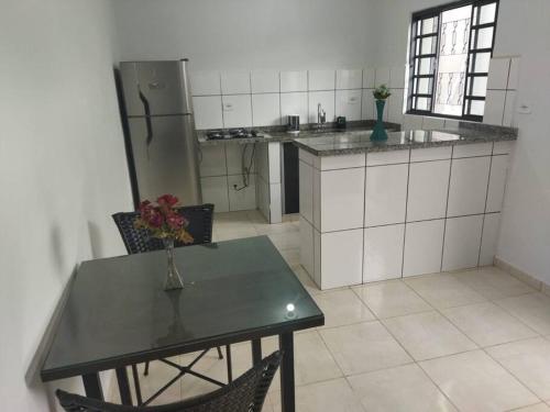 a kitchen with a table with a vase of flowers on it at Kitnet 3 - próximo ao centro de Jacareí in Jacareí