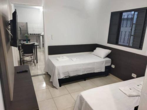 um quarto com duas camas e uma mesa em Kitnet 3 - próximo ao centro de Jacareí em Jacareí