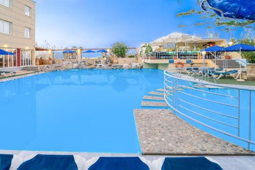 una piscina en un complejo con agua azul en Futura Hotel, en Máleme