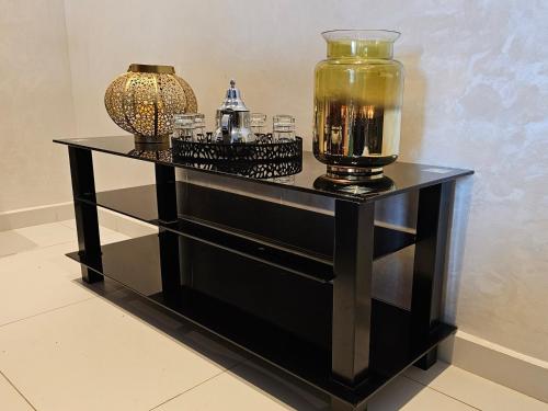 Una mesa negra con un jarrón encima. en Magnifique vue, charme unique. en Kenitra