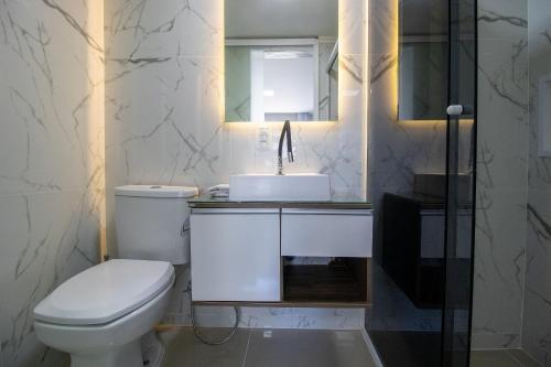 a bathroom with a white toilet and a sink at CB62 - Duplex, 4 Dorm Climatizados, Churrasqueira in Balneário Camboriú