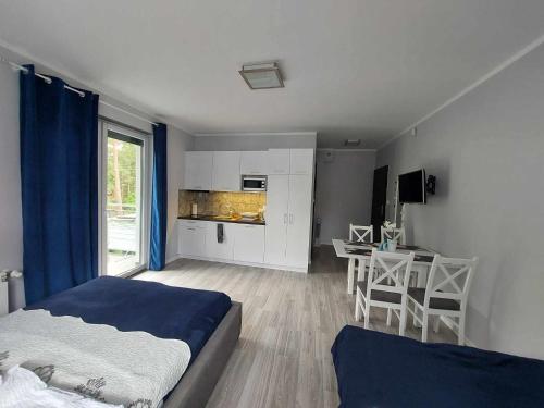 a bedroom with a bed and a table and a kitchen at Villa6 in Pobierowo