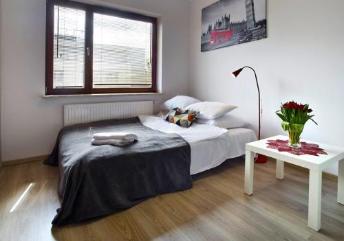 um quarto com uma cama grande e uma mesa em Apartment 1-bed Kłobucka P&O Serviced Apartments em Varsóvia