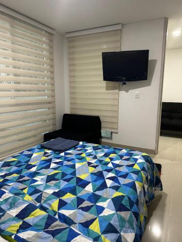 a bedroom with a bed and a flat screen tv at APARTA ESTUDIO LA VEGA in La Vega