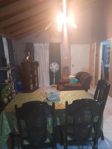 a living room with a table with chairs and a couch at The Whitewater Meadows in Spanish Town