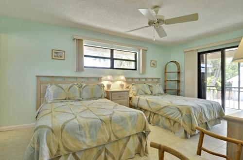 a bedroom with two beds and a ceiling fan at Villa Riolo in Islamorada