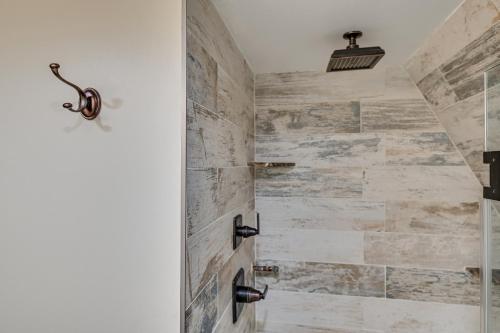 a bathroom with a walkin shower with stone walls at Charming Hunter A-Frame Walk to Ski Lift! in Lanesville