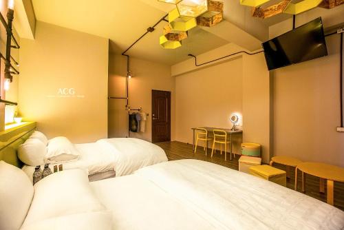 a room with two beds and a table with chairs at Art Zone in Hualien City