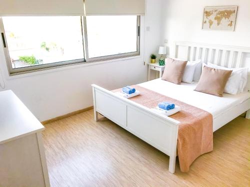een slaapkamer met een wit bed en 2 handdoeken bij Seaview Apartment (Excellent Location) in Larnaka