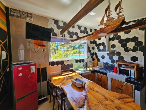 cocina con mesa de madera y nevera roja en Cabaña Bienvenidos a Bordo en Algarrobo