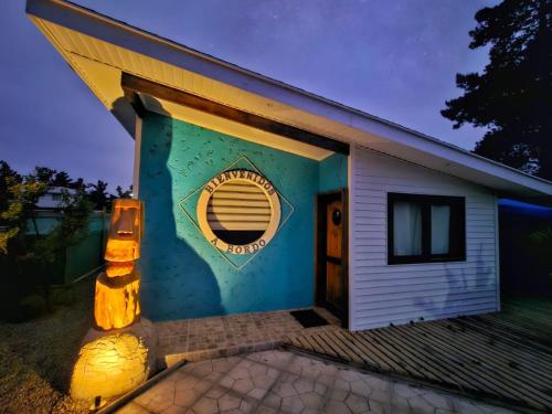 una casa con una pared azul y una ventana en Cabaña Bienvenidos a Bordo, en Algarrobo