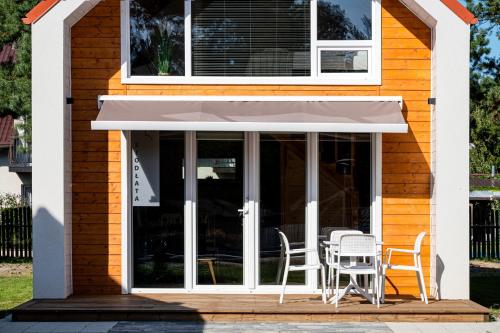 a patio with chairs and an awning on a house at Domki Mewa in Jantar