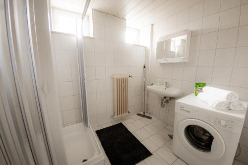 a white bathroom with a washing machine and a sink at Yello Homes - großes Apartment - Am Waldrand, 15 min bis Nürnberg Messe, für 8 Personen, 2 WC's in Schwarzenbruck