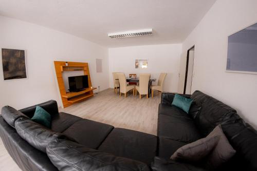a living room with a couch and a dining room at Yello Homes - großes Apartment - Am Waldrand, 15 min bis Nürnberg Messe, für 8 Personen, 2 WC's in Schwarzenbruck
