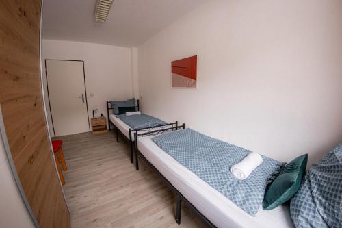 a room with two beds and a mirror at Yello Homes - großes Apartment - Am Waldrand, 15 min bis Nürnberg Messe, für 8 Personen, 2 WC's in Schwarzenbruck