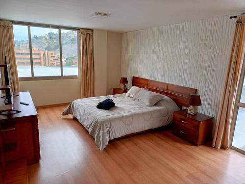 a bedroom with a bed with a backpack on it at Depar Rio Cuenca - Confortable in Cuenca