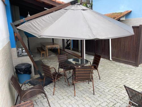 聖塞巴斯蒂安的住宿－Chalés Camburi，庭院内桌椅和遮阳伞