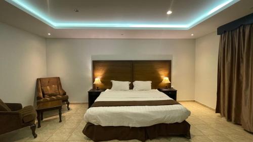 1 dormitorio con 1 cama grande y 1 silla en فندق بوابة العالية, en Medina