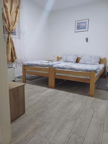 twee bedden in een kamer met een houten vloer bij Apartman “Sanja” in Pirot